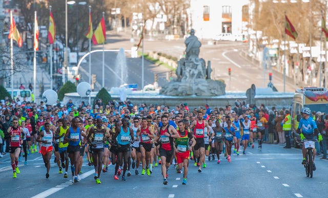 cientos de corredores pasan por delante de la fuente de la plaza de cibeles de madrid en el movistar media maratón de madrid