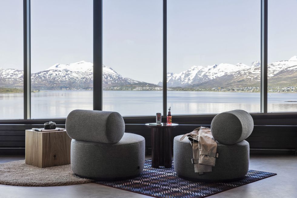 a group of chairs next to a window overlooking a body of water