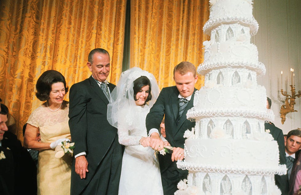 lyndon and claudia johnson watching daughter cut wedding cake