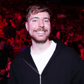 mrbeast aka jimmy donaldson smiles at the camera, he wears a white tshirt and black zip up jacket