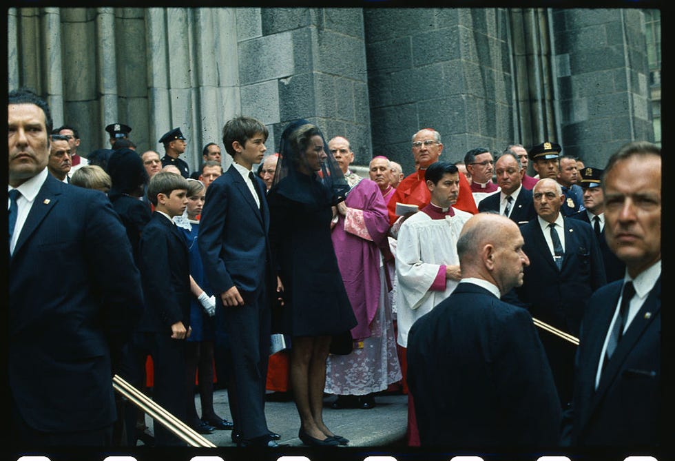ethel kennedy stands on the steps of a church in mourning clothes with her children as crowds look on
