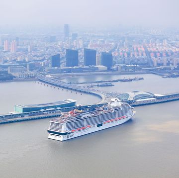 a large ship in the water with a city in the background
