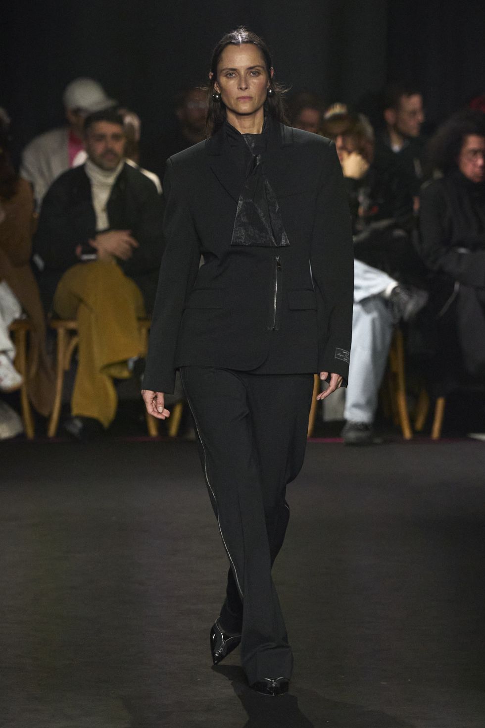 a person in a suit walking down a runway