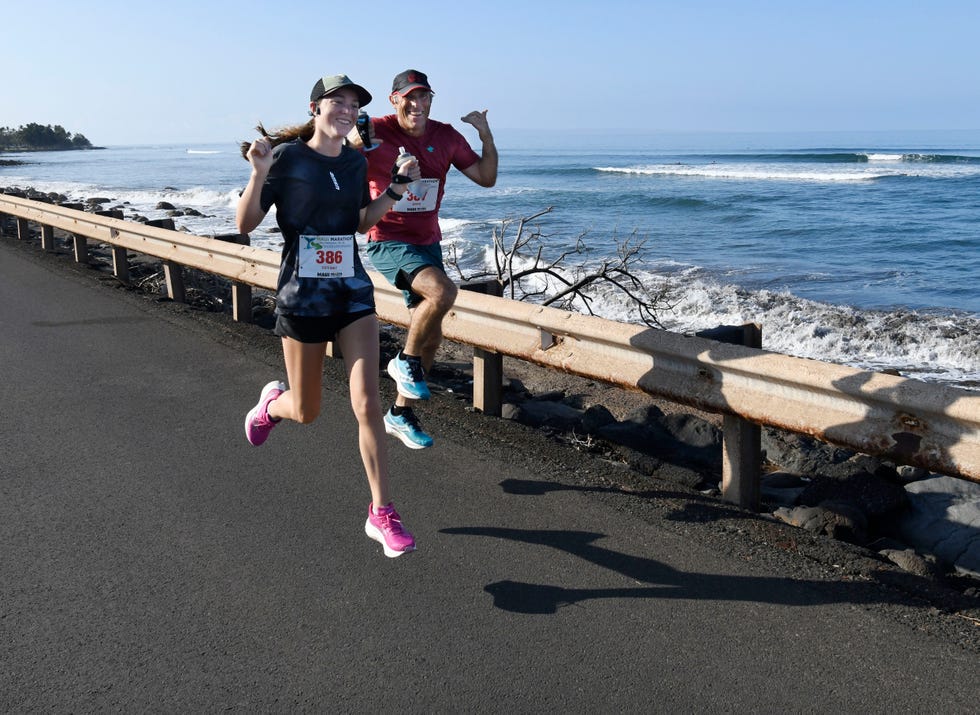 runners participating in a marathon along a coastal road