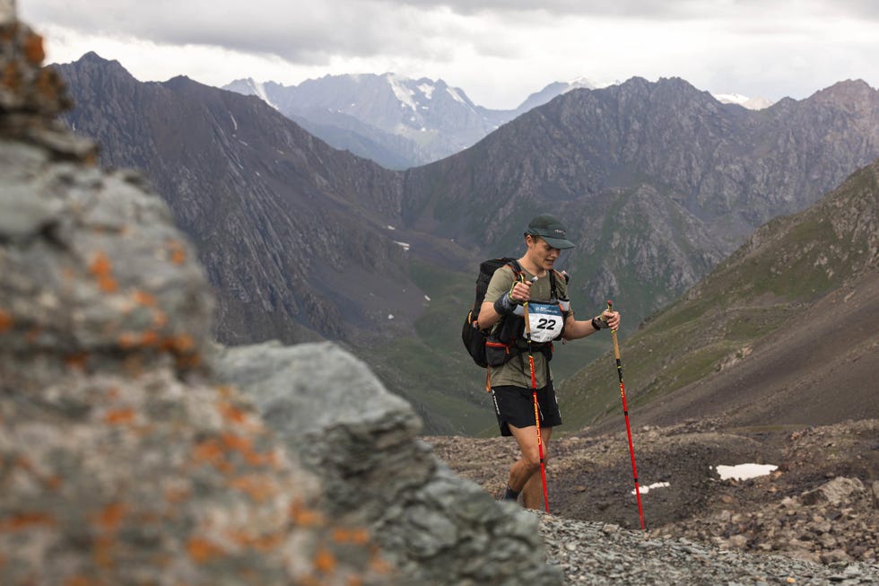 person with walking poles trekking in a mountain range