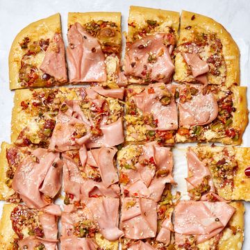 thin crisp pizza topped with olive salad, salami, provolone, and parmesan