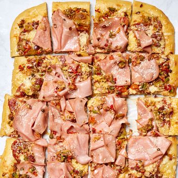 thin crisp pizza topped with olive salad, salami, provolone, and parmesan