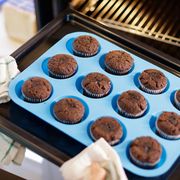 chocolate cupcakes in blue silicone muffin tin going into oven