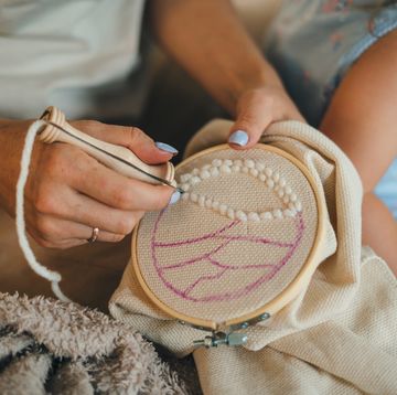 woman doing punch needle on embroidery hoop