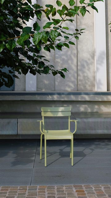 a yellow bench under a tree