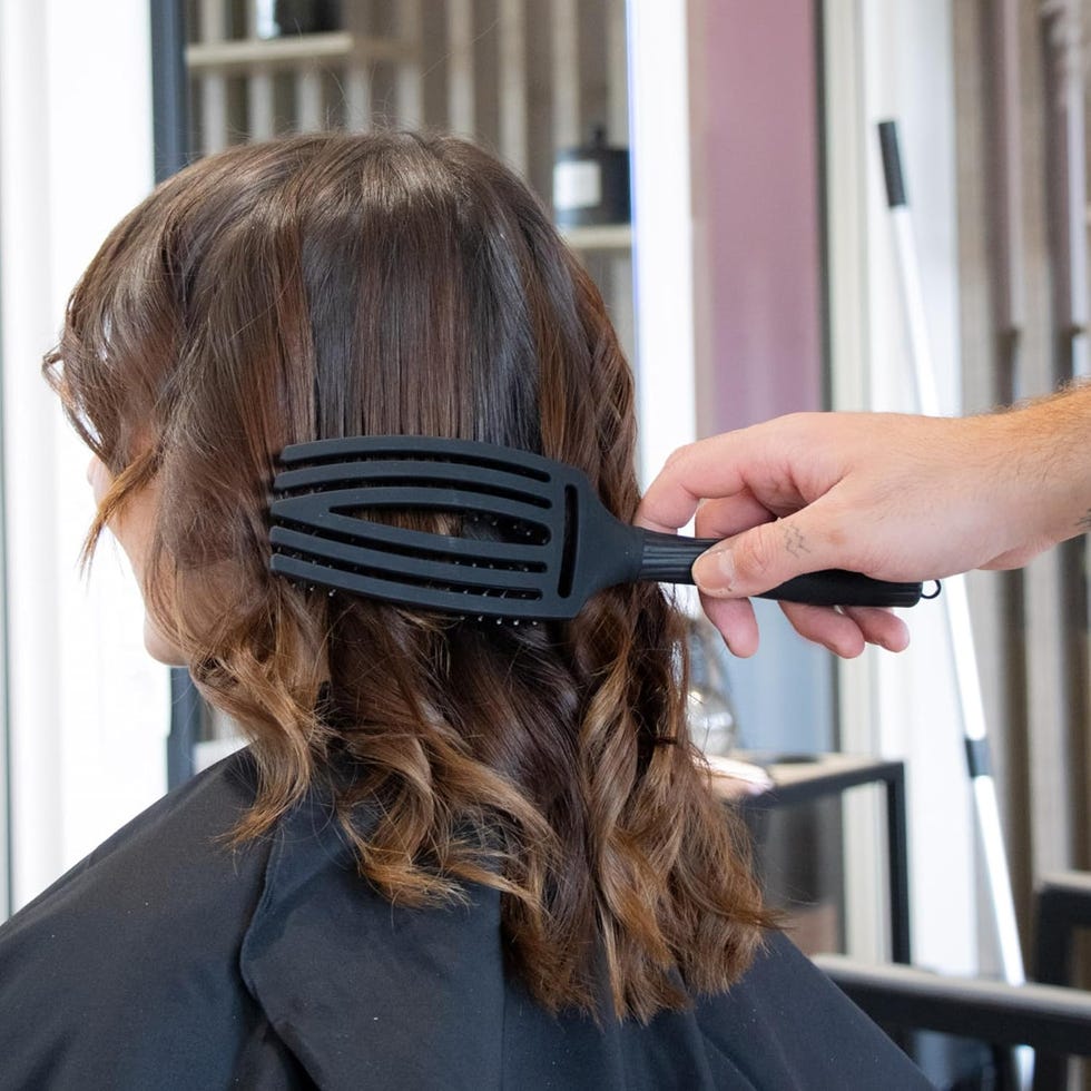 mujer cepillando pelo ondulado