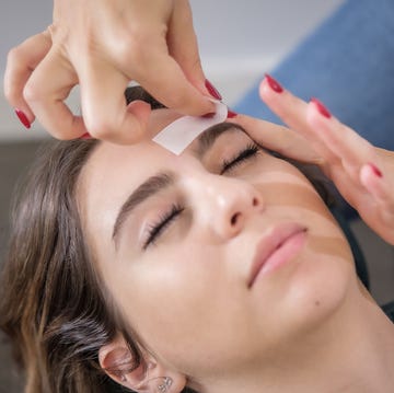 A una mujer le depilan las cejas en un salon de belleza una mujer se depila las cejas en un salon de belleza