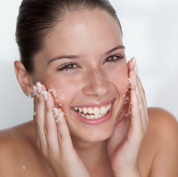 Una chica joven se hace una exfoliacion en la cara una chica joven se hace una exfoliacion en la cara