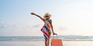 happy asian woman with sunhat enjoy travel on the beach in summer
