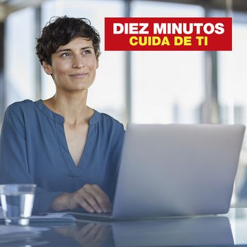 smiling businesswoman sitting at desk in office with laptop