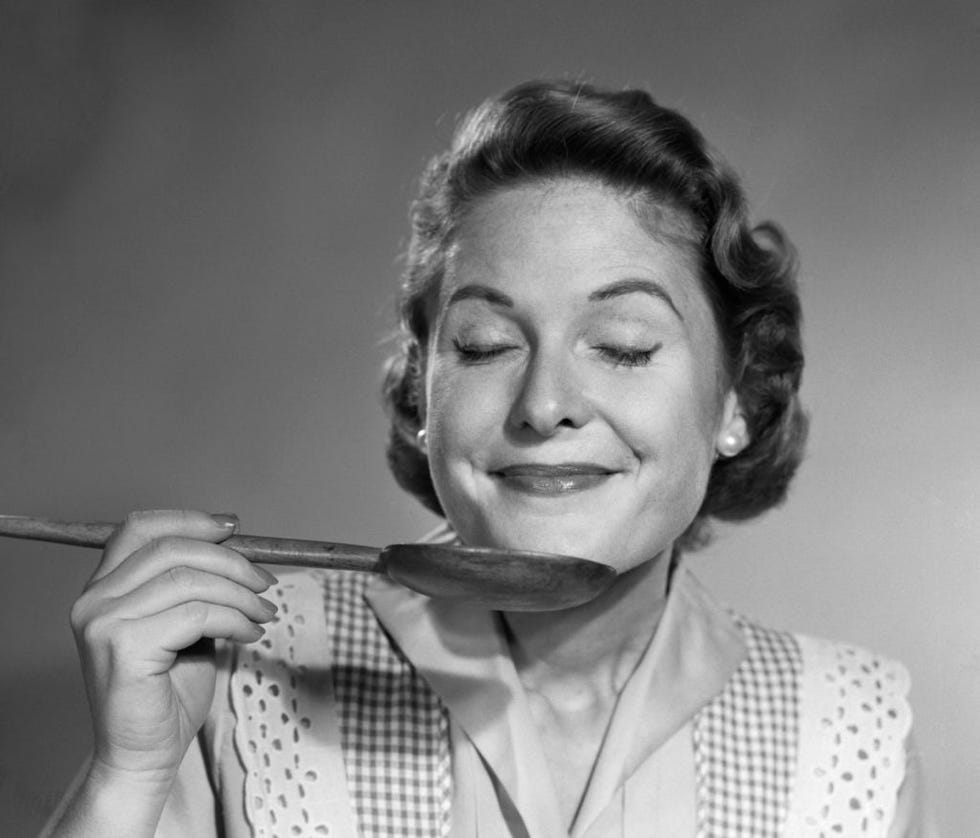 mujer con peinado tipico de los anos 50 sujeta un cucharon cerca de su boca