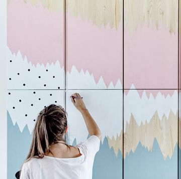 mujer pintando a mano un armario