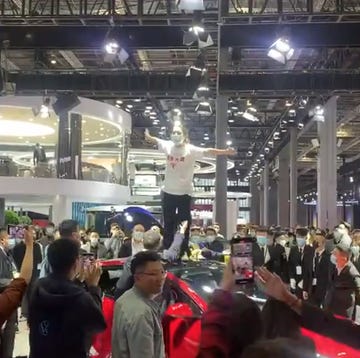 mujer protesta sobre un tesla en el salón de shanghai