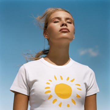 Un mujer joven toma el sol con una camiseta con un sol amarillo mujer tomando el sol