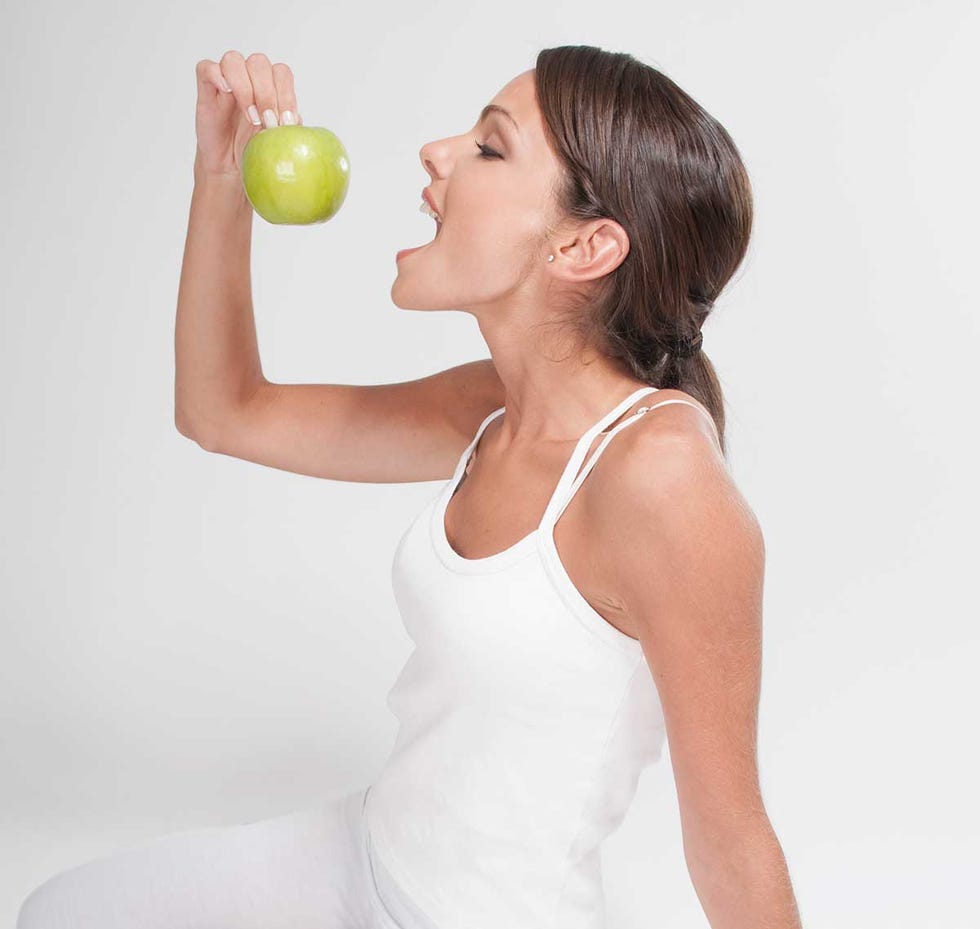 Mujer come manzana verde