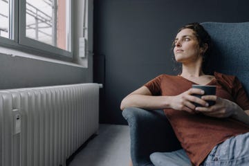 mujer se toma un café junto a la calefacción