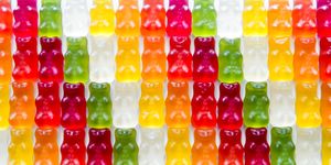 Multi colored gummy bears candy in a row arrangement close-up studio shot