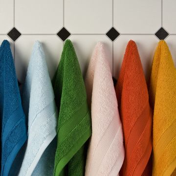 multi colored towels hanging in a row on the wall