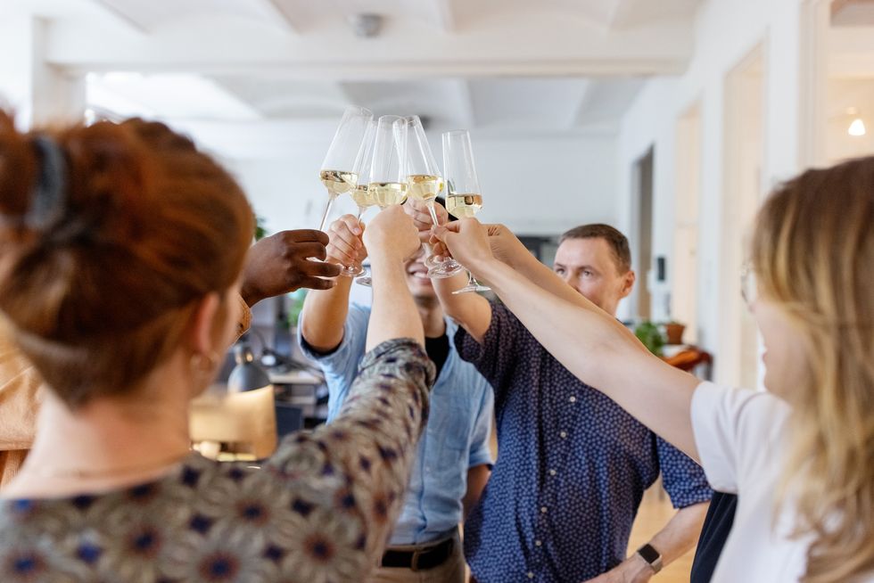multi ethnic business people toasting champagne in office