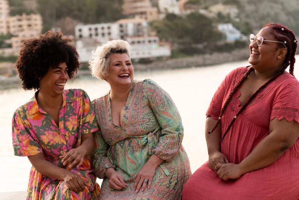 multi ethnic friends chilling and laughing next to the sea