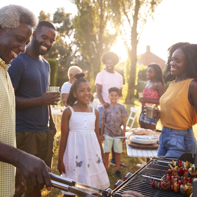 Multi generation black family barbecue, grandad grilling