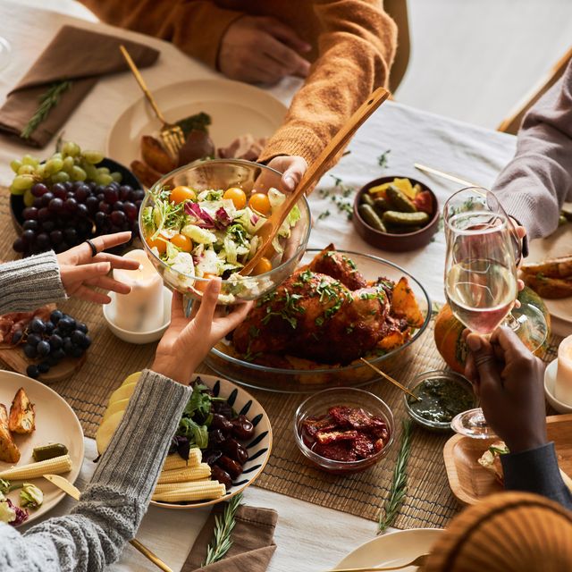 multiethnic group of people at festive dinner table celebrating thanksgiving