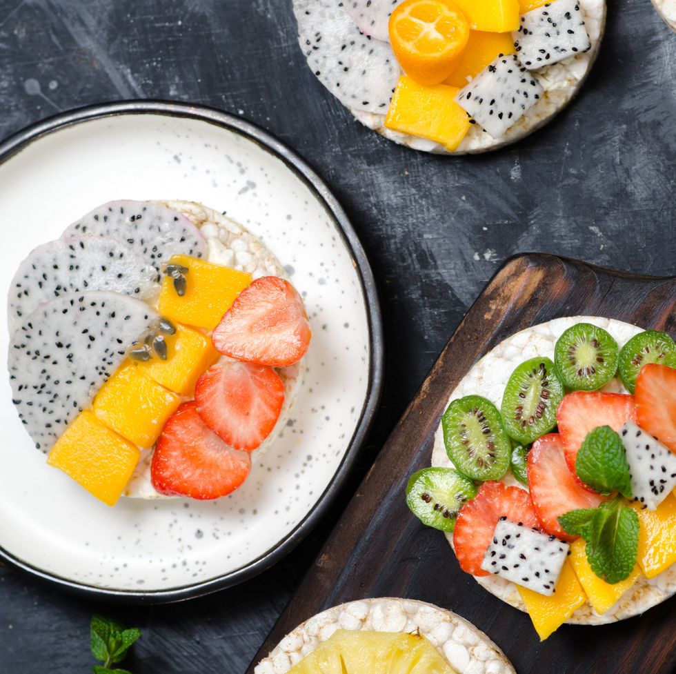 multigrain rice cakes sandwich with berries, fruit and cream cheese for healthy breakfast