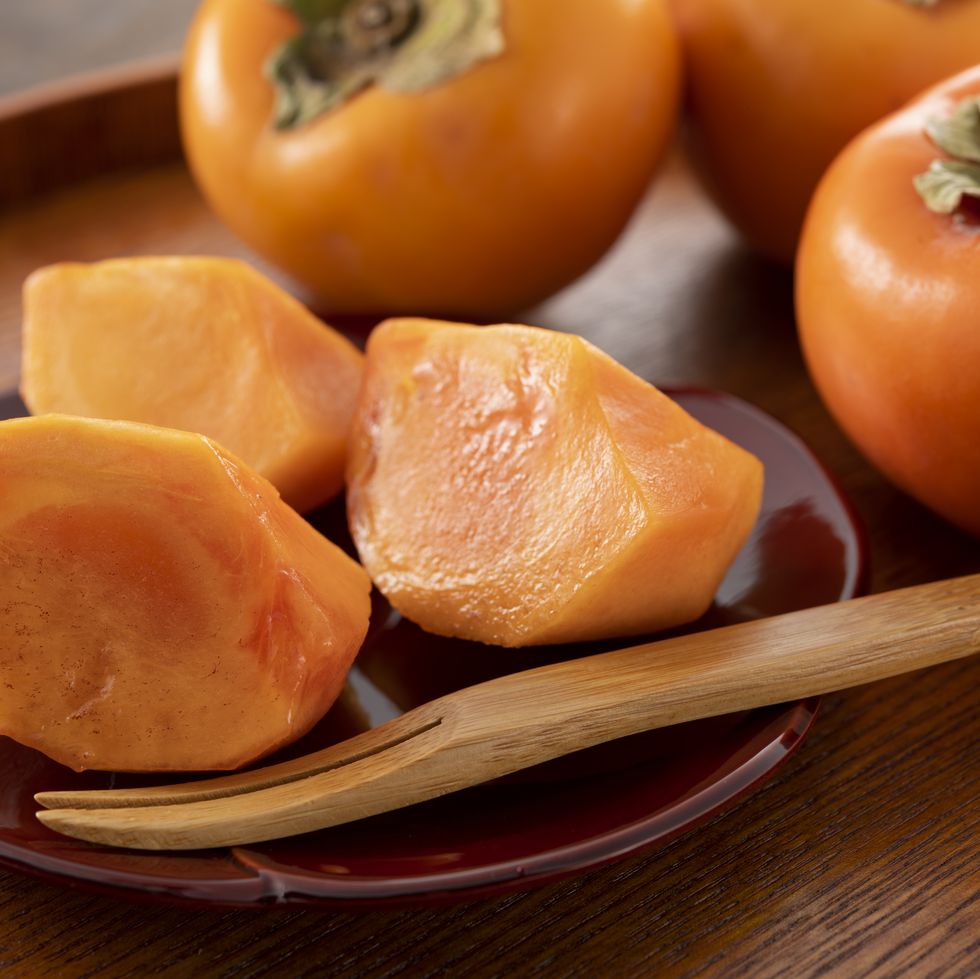 multiple persimmons lined up on the tablemultiple persimmons lined up on the table