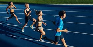 multiracial athletes practicing running on racetrack