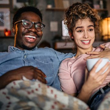multiracial loving couple watching tv in the evening