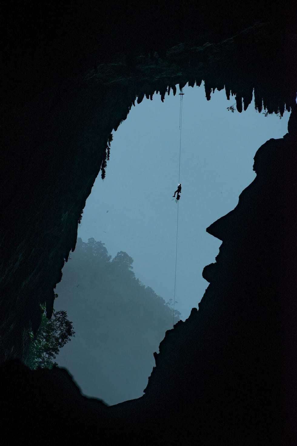 Een expeditielid op weg naar het dak van de Deer Cave bungelt boven een rotsformatie waarin het gezichtsprofiel van Abraham Lincoln lijkt gebeiteld Dit presidentile portret is geheel natuurlijk ontstaan en is een van de vele opmerkelijke verschijnselen in het grottenstelsel