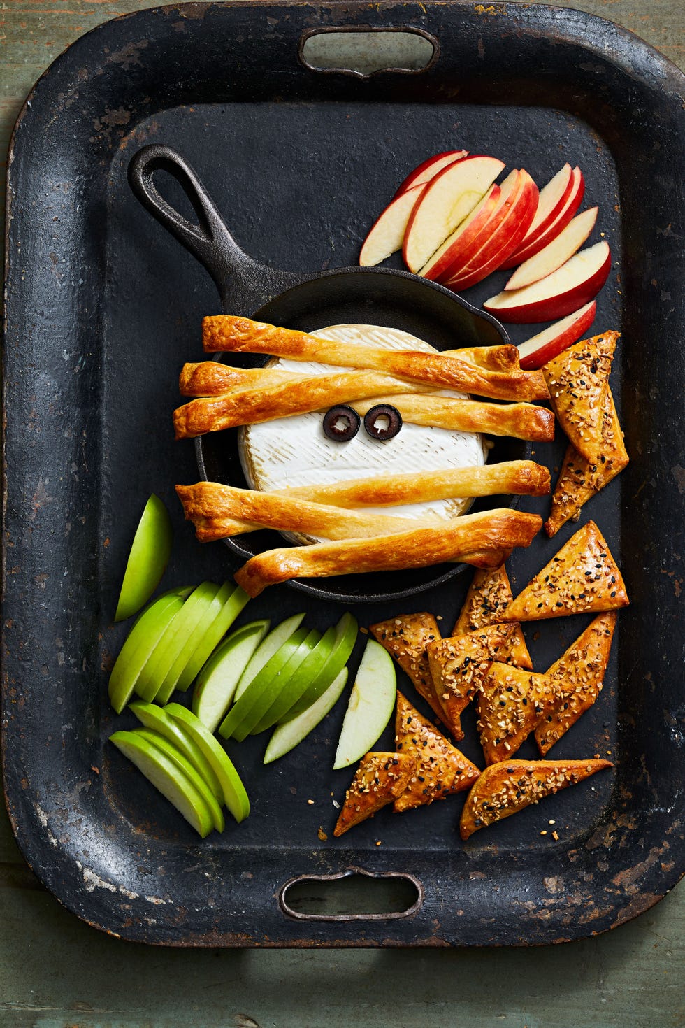 wheel of brie that looks like a mummy with puff pastry on top