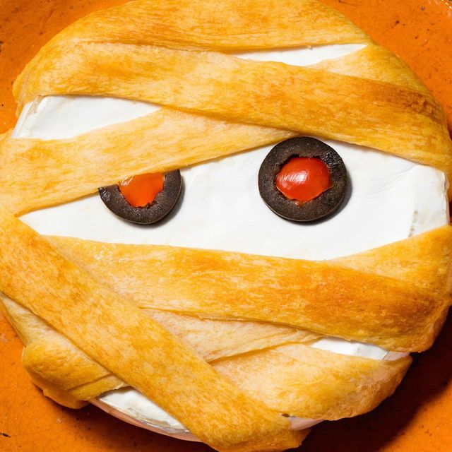 brie cheese wrapped in puff pastry with pepperoni and olive eyes