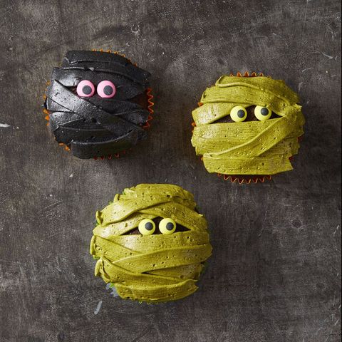 green and black cupcakes that look like mummies