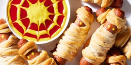 hot dogs with mustard eyes wrapped in crescent dough with cheese and served a mustard and ketchup dip