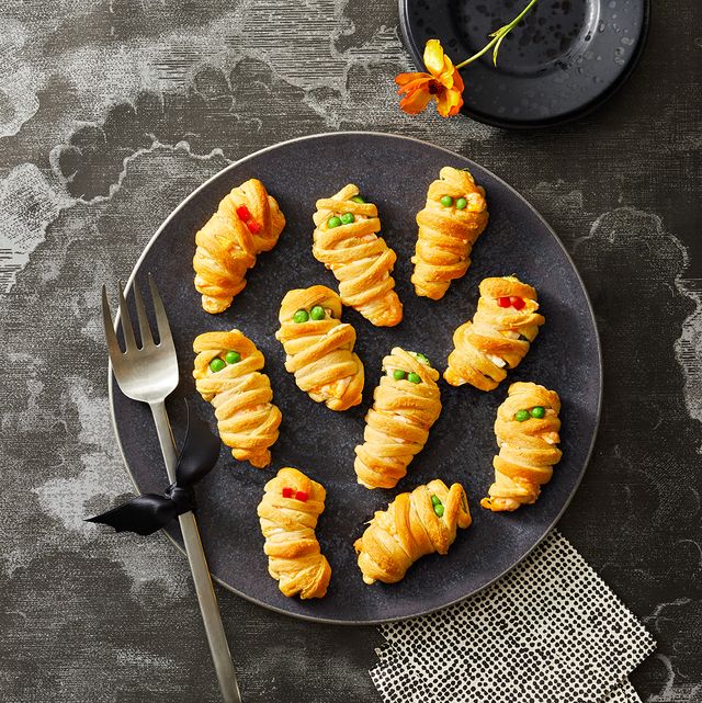 mummy jalapeno poppers on a black plate for halloween