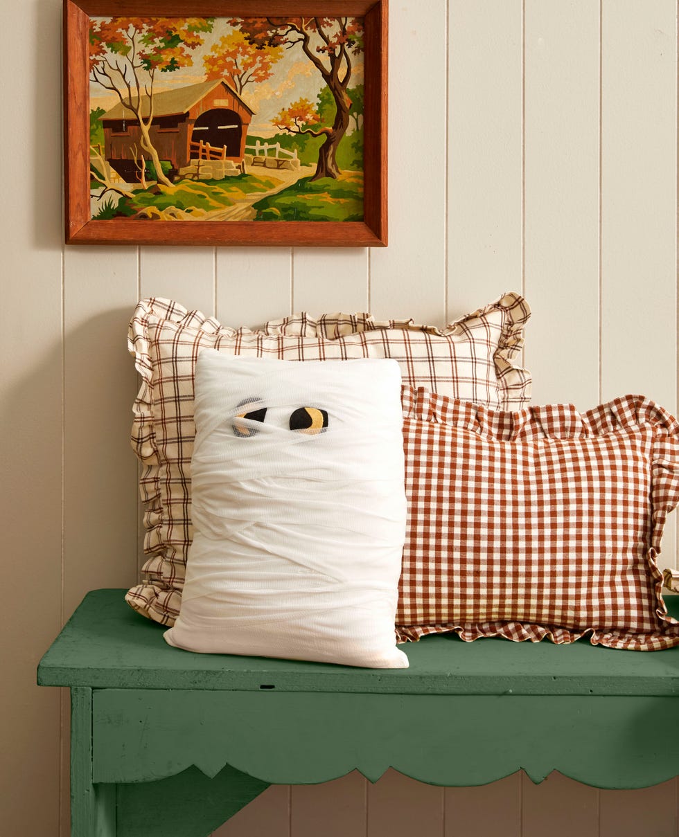 a white throw pillow wrapped in gauze with felt eyes to look like a mummy