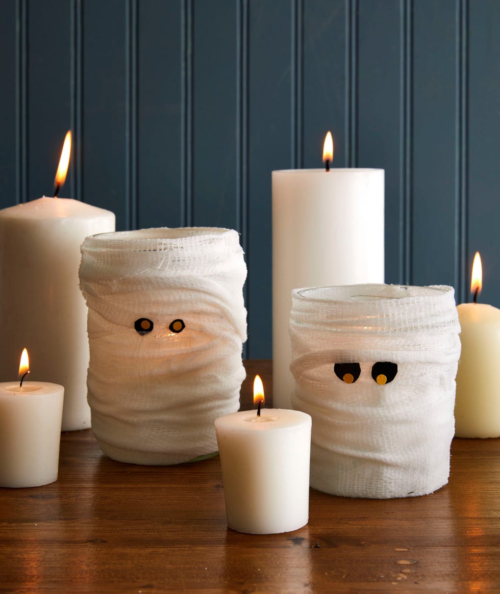 wide mouth mason jars wrapped in gauze with felt eyes so they look like mummies