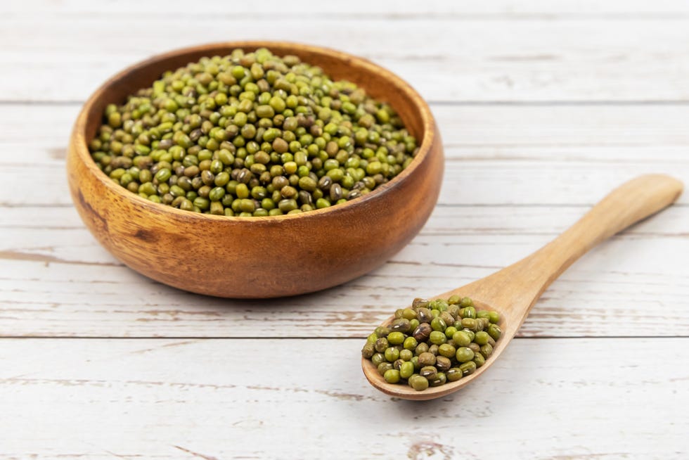 mung beans in a wooden bowl with a wooden spoon