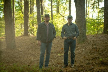 two men standing in the woods