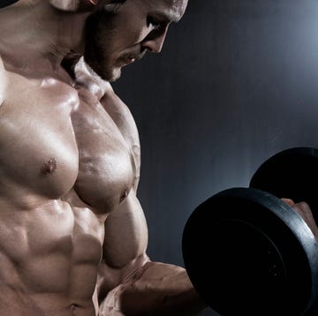 muscular man doing exercise with dumbbells