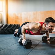 muscular man doing pushup exercise with dumbbell