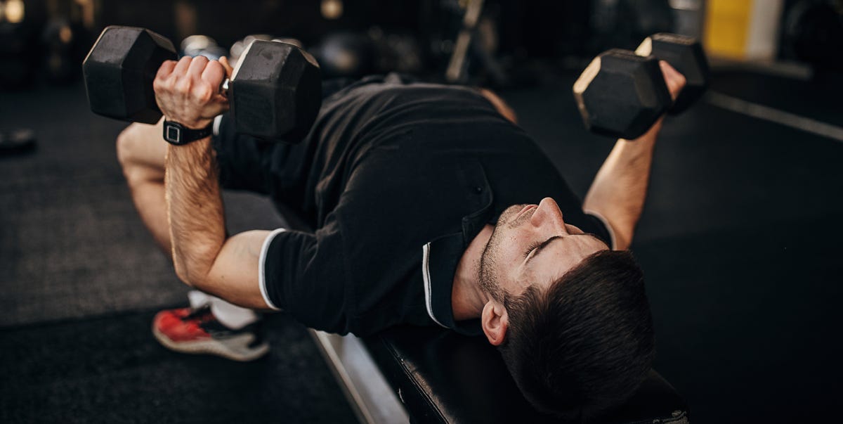 muscular man exercising on weight with dumbbells