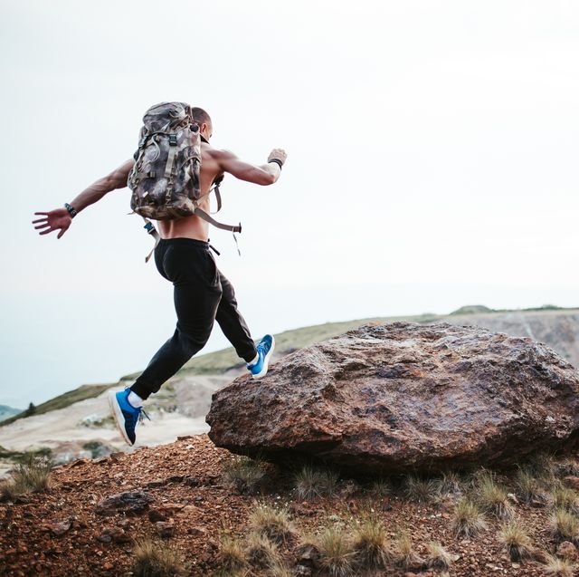 muscular man running on mountain