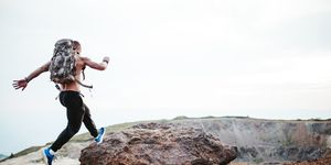muscular man running on mountain